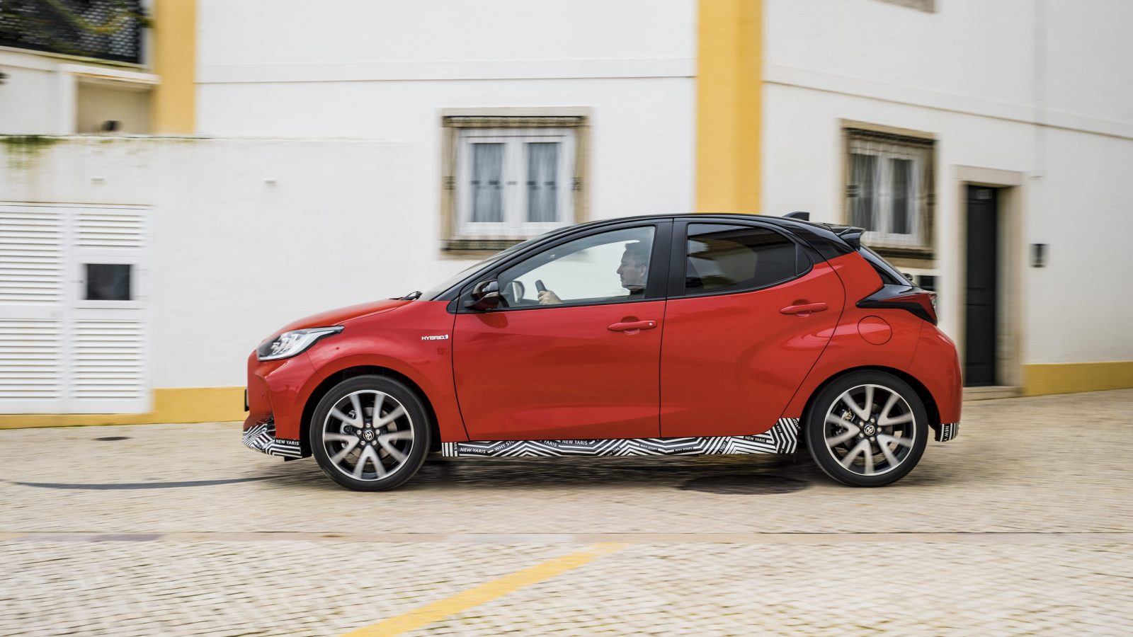 Side view of prototype Toyota Yaris driving on a cobbled road