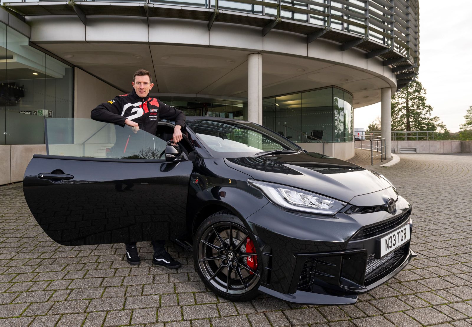 Elfyn Evans poses with his new Toyota GR Yaris outside Toyota GB's headquarters