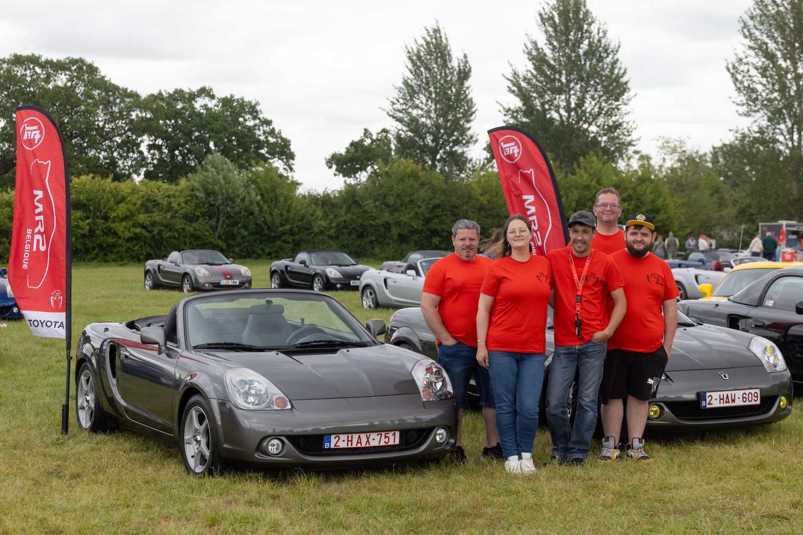 MR2 National Driver's Day flags and people standing in front of 2 seater cars Toyota
