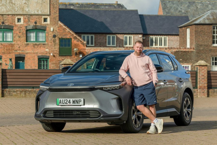 Ash Tucker, owner of the bZ4X, leans against his car in his home town of King's Lynn.