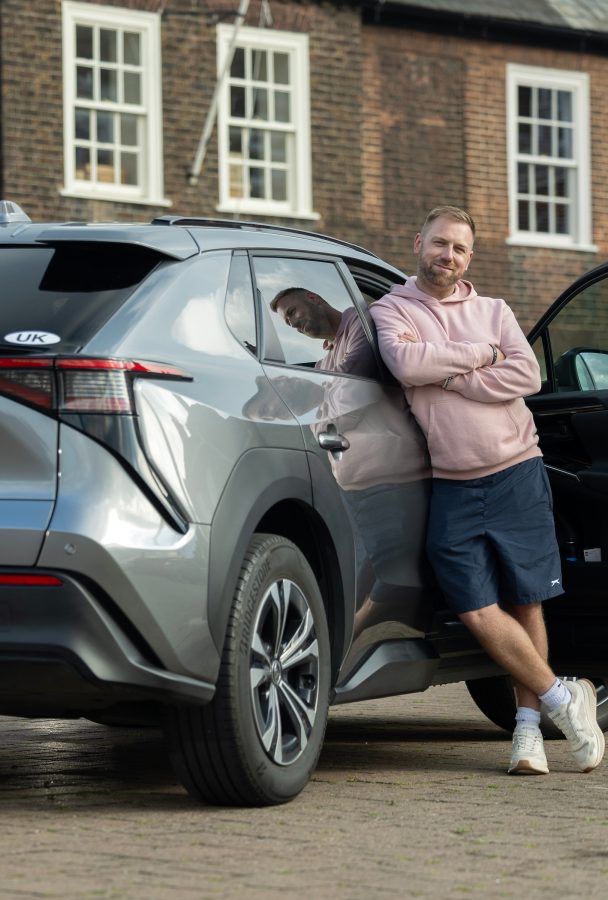 Ash Tucker (owner of a bZ4X) leans against his vehicle.