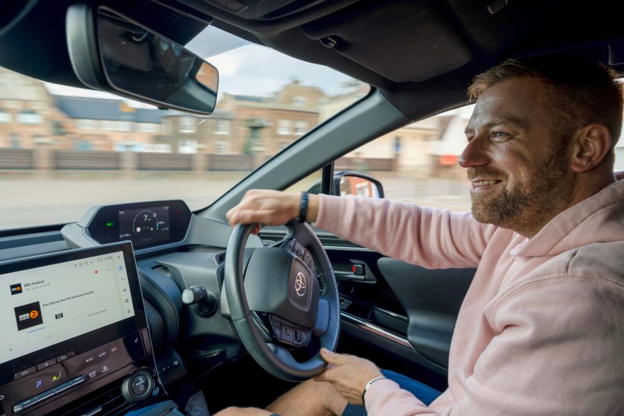 Interior shot of the Toyota bZ4X, whilst owner drives the vehicle, smiling as he does so.
